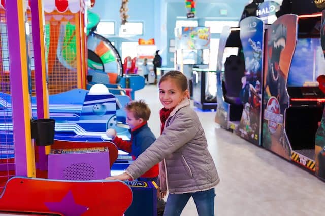 Two kids playing in an arcade 