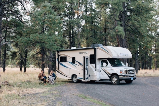 A couple sitting beside their RV