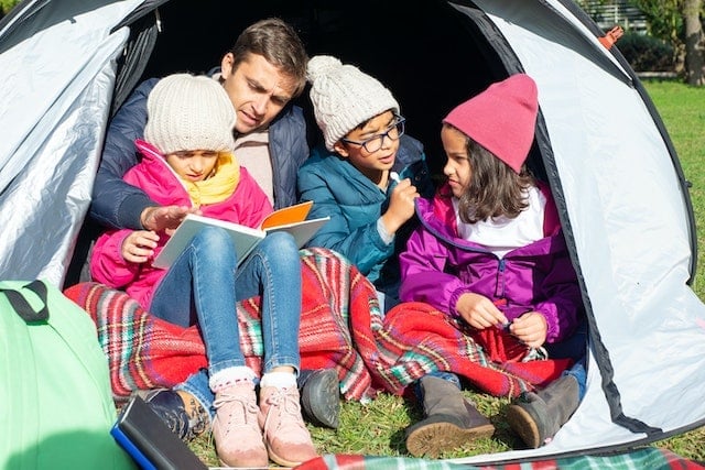 A man and his kids in a tent