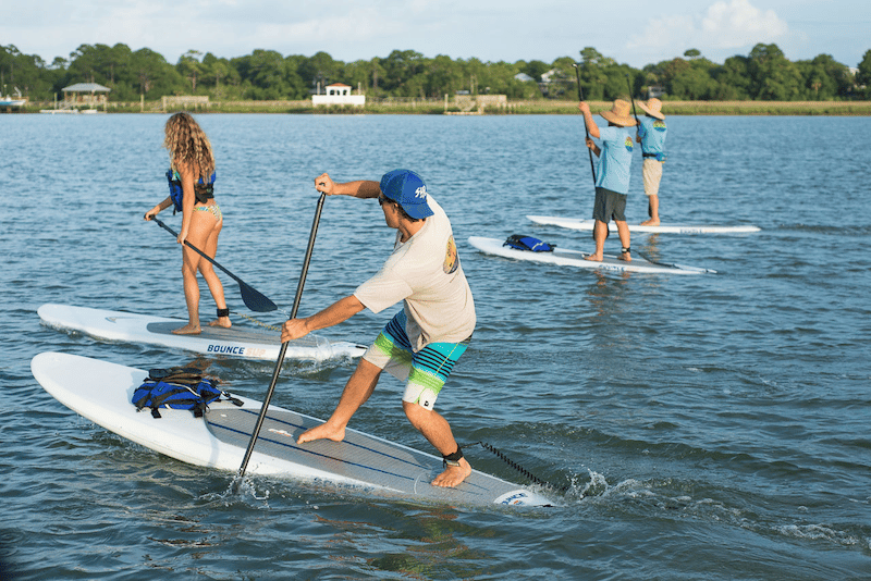 Young adults paddle boarding 