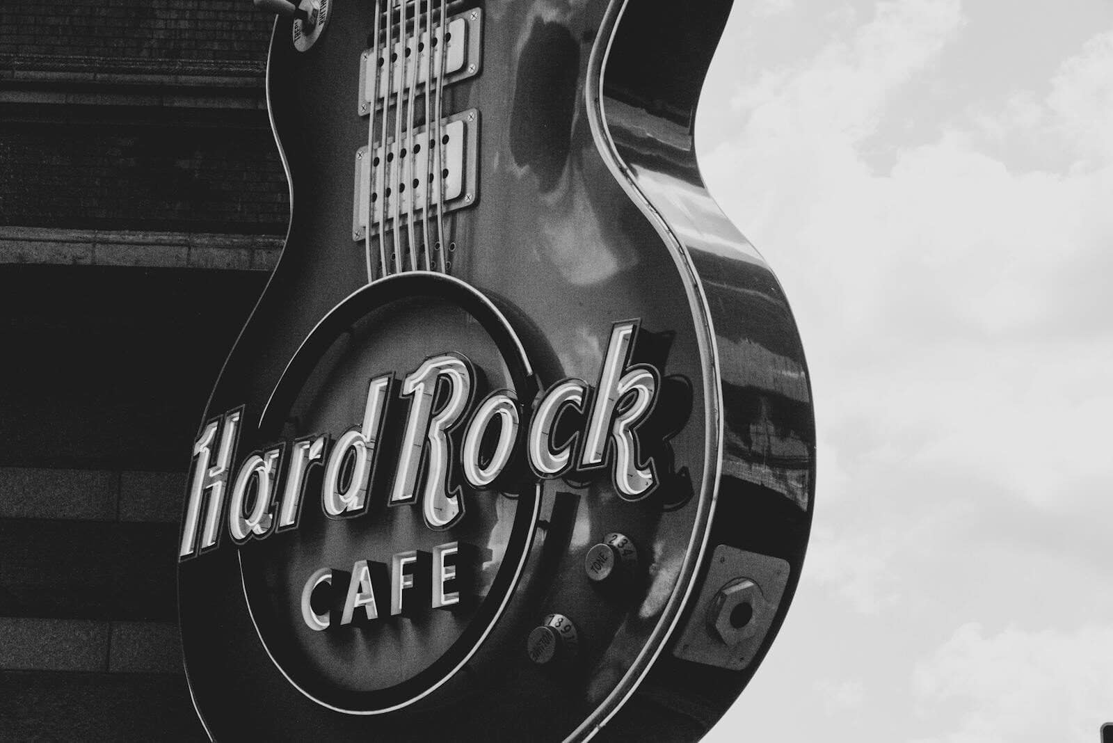 Black and white photo of the Hard Rock Café guitar-shaped sign against a cloudy sky. Discover the Best Dining Experience at Hard Rock Cafe Myrtle Beach
