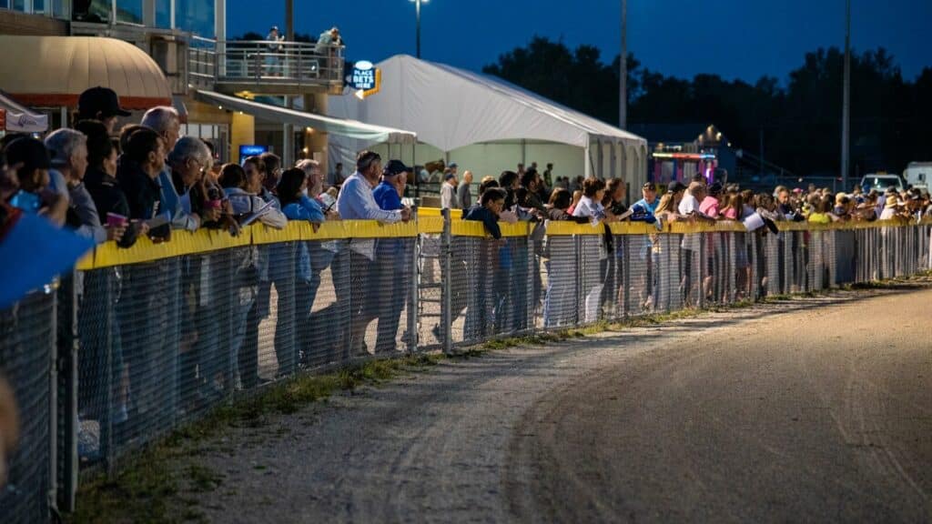 a crowd of people watching a race at night