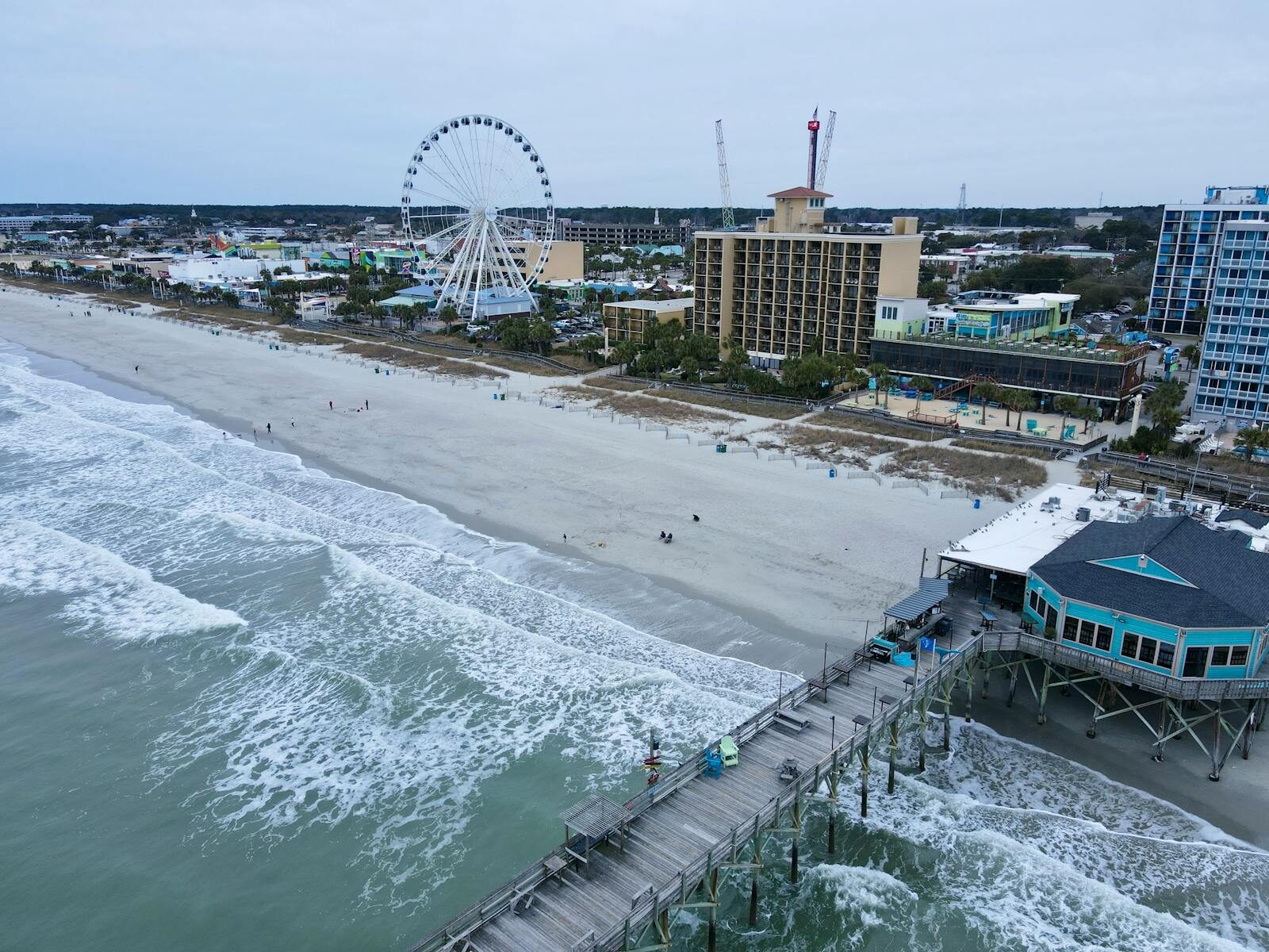 Photo by Joel Aerial shot of Myrtle Beach with iconic pier and ferris wheel, capturing coastal beauty.