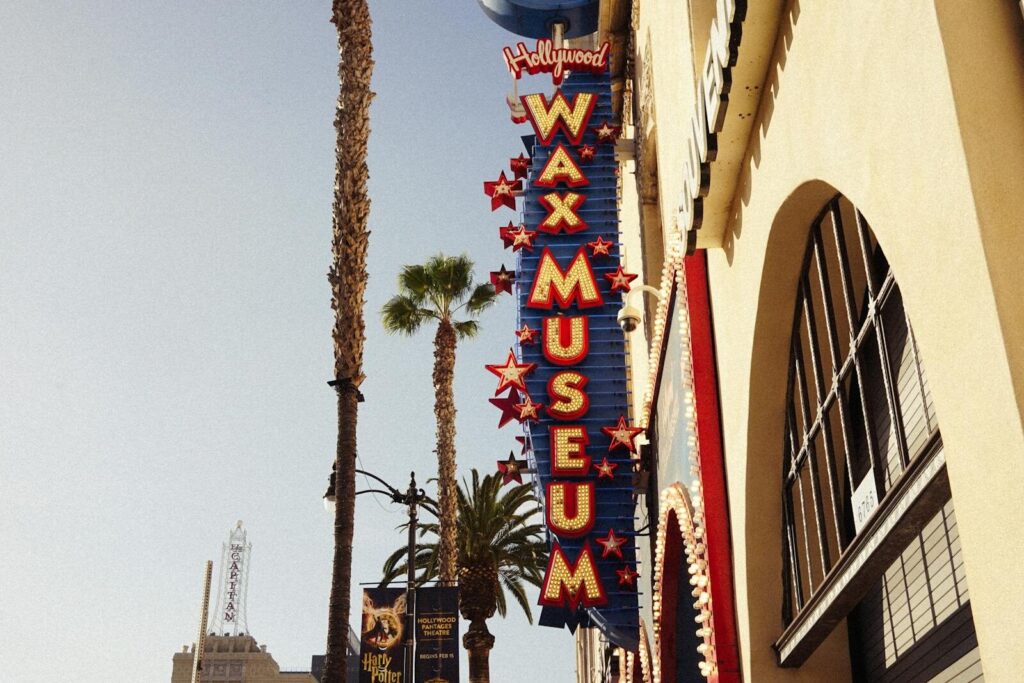 Discover the Magic of Hollywood at Hollywood Wax Museum Myrtle Beach 11 Hollywood Wax Museum sign with palm trees on sunny day, iconic Los Angeles location.