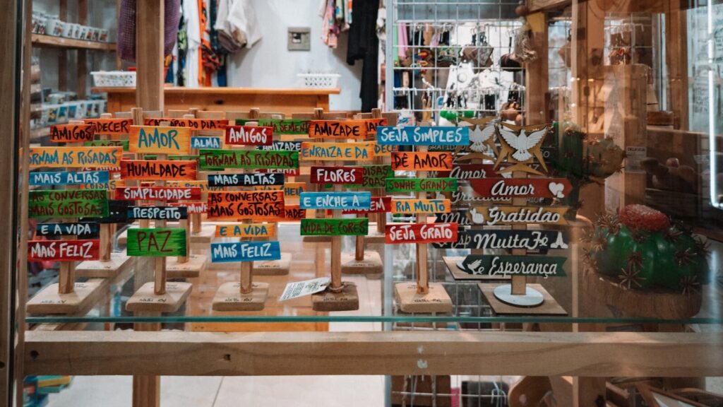 Vibrant wooden signs with uplifting messages on display in a cozy boutique setting.