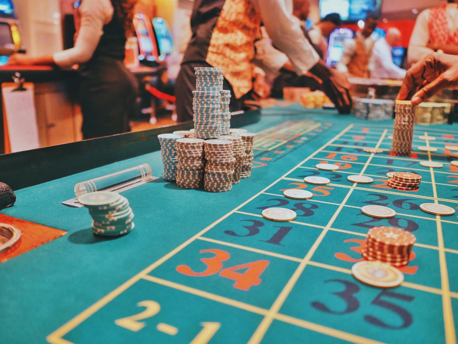 A vibrant view of a casino roulette table with poker chips and players engaged in gambling.