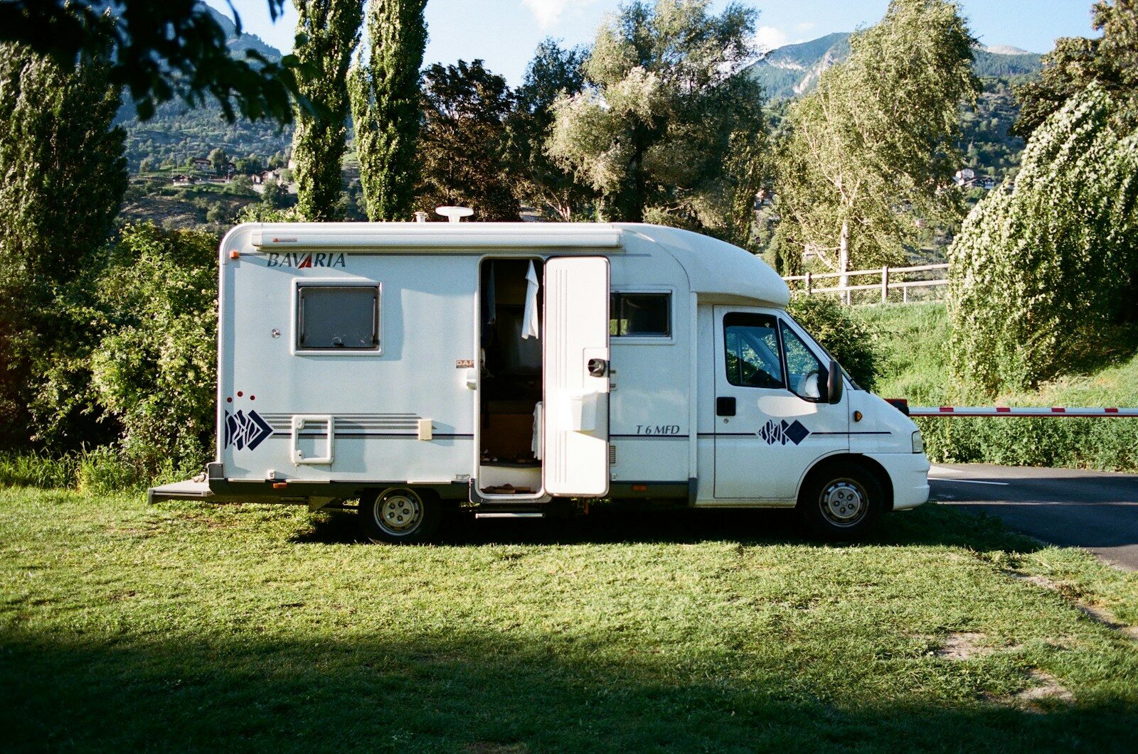 Photo by lucas Favre white and brown rv trailer on green grass field during daytime