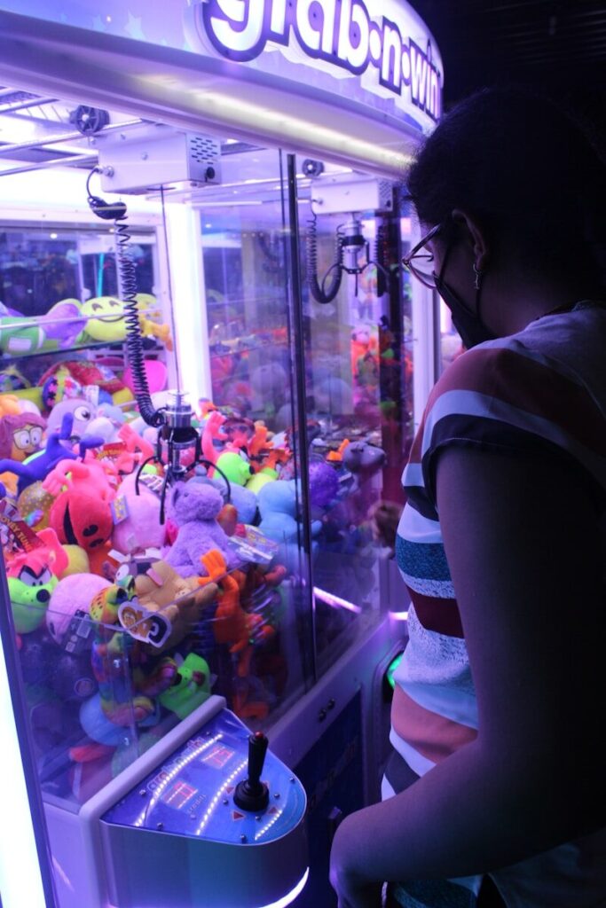 Dave and Busters Myrtle Beach: A Game and Dining Destination 11 a woman standing in front of a vending machine filled with stuffed animals