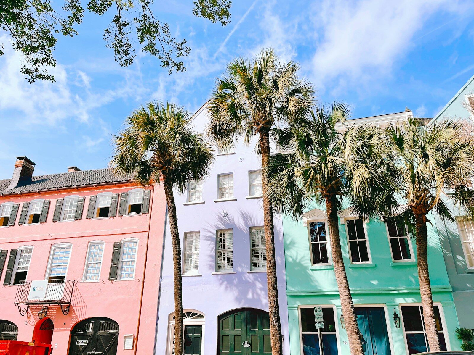 Photo by Tyrone Sanders green palm tree near white and pink concrete building during daytime
