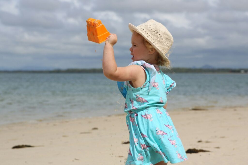 A Complete Beach Vacation Packing List for All Kinds of Travelers 11 a little girl holding a toy on a beach